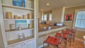 een keuken met stoelen met rode kussens en een aanrecht bij Portofino House in South Padre Island