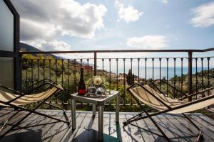 a balcony with two chairs and a table with a bottle of wine at B&B Il Parco in Monterosso al Mare