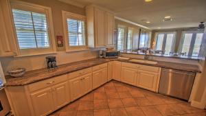a kitchen with white cabinets and a counter top at Portofino House in South Padre Island
