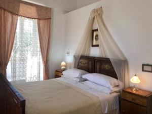 a bedroom with a canopy bed and a window at Masseria Rienzo in Ostuni