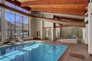 a large swimming pool in a building with a large window at 2062 The Pines Condo in Keystone