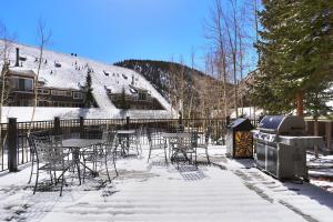 a grill and tables and chairs in the snow at 2062 The Pines Condo in Keystone