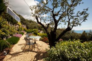a table and chairs in a garden with a tree at B&B Il Parco in Monterosso al Mare