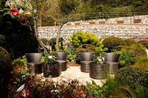 a garden with several black pots with flowers at B&B Il Parco in Monterosso al Mare