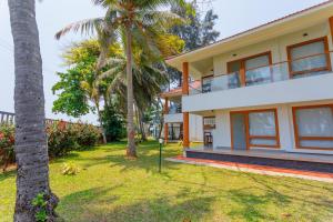 a house with palm trees in front of it at Kappad Beach Resort in Kappad