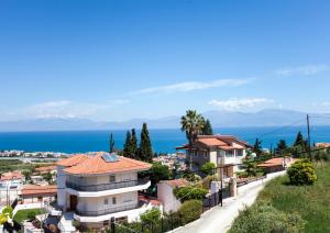 a city with houses and the ocean in the background at Villa O in Melíssion