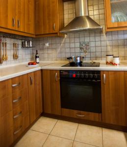 uma cozinha com armários de madeira e um forno com placa de fogão em Villa O em Melíssion