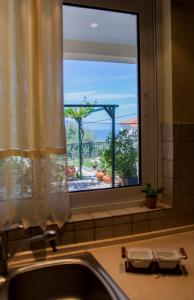 um lavatório de cozinha com uma janela com vista em Villa O em Melíssion