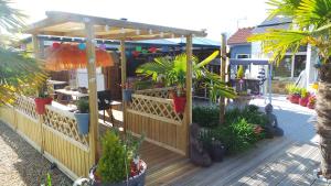 a wooden deck with plants and a pergola at Casa Bihan Ty Coat in Lannion
