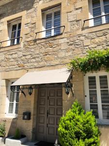 um edifício com uma porta castanha e toldo em Les Maisons du Périgord em Terrasson