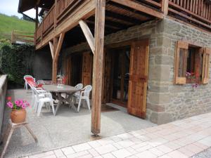 un patio avec une table et des chaises et un bâtiment dans l'établissement Gîte le Clapier, à Theys