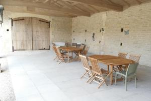 two wooden tables and chairs on a patio at Gites Les Grandes Ecures in Mons