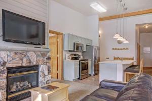 salon z kominkiem i telewizorem z płaskim ekranem w obiekcie 5983 Hidden River Lodge Condo w mieście Keystone