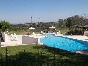 een zwembad met stoelen en parasols in een tuin bij Hotel Rural Quinta de Santo Antonio in Elvas