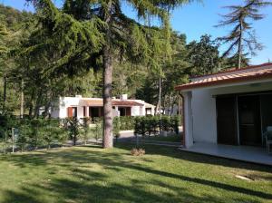 a house with a tree in the yard at Villaggio Turistico La Mantinera - Appartamenti de Luxe in Praia a Mare