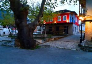 a house with a tree in front of it at Little Island Resort in Nísos Ioannínon