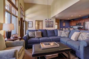 a living room with a blue couch and a table at 8890 The Springs Condo in Keystone