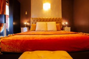 a bedroom with a large bed with a orange blanket at B&B Il Parco in Monterosso al Mare