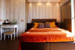 a bedroom with a bed with an orange blanket and a table at B&B Il Parco in Monterosso al Mare