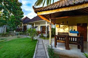 a house with a bench in the yard at Pemuntalan Guesthouse in Nusa Lembongan
