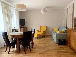 a living room with a table and chairs and a couch at Charlotte by Q4Apartments in Gdańsk