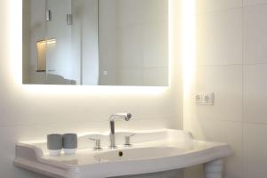 a white bathroom with a sink and a mirror at Fachwerkhaus in Ahrenshoop