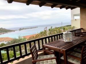 a wooden table on a balcony with a view of the ocean at Mare33 in Santa Teresa Gallura