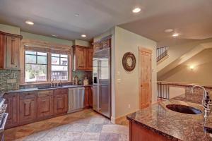 a kitchen with wooden cabinets and a stainless steel refrigerator at 39C Union Creek Townhomes West Townhouse in Copper Mountain