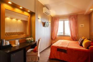 a bedroom with a bed and a desk and a mirror at B&B Il Parco in Monterosso al Mare