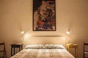 ein Schlafzimmer mit einem Bett und einem Wandgemälde in der Unterkunft Casa D'Arte Shoshanna in Avola