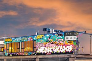 a building covered in graffiti on the side of it at the niu Hide in Berlin