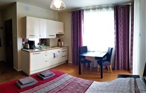 a room with a kitchen and a table with a bed at Lux Apartment Cosy in Polanica-Zdrój