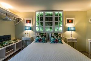 a bedroom with a large white bed with two lamps at My Bed in pico in Madalena