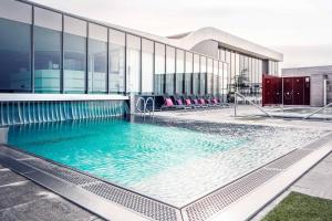 a large swimming pool in front of a building at Fletcher Wellness-Hotel Sittard in Sittard