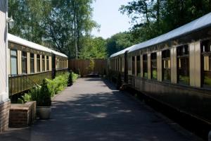 twee treinen geparkeerd naast elkaar op een stoep bij The Old Railway Station in Petworth