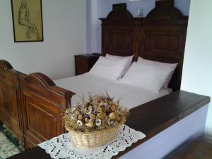 a bedroom with a bed with a basket on a table at Fattoria del pino in Miasino +10 photos