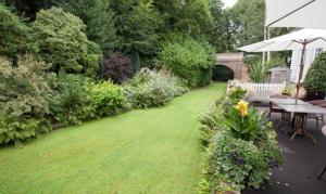 a garden with a lawn with a table and chairs at The Old Railway Station in Petworth