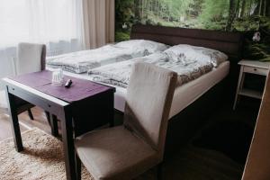 a bedroom with a bed and a desk and a table and chair at Pension Leprich in Bad Goisern