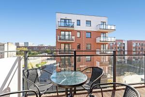 een balkon met een tafel en stoelen en een gebouw bij NORDBYHUS Apartamenty Nowa Grobla in Gdańsk