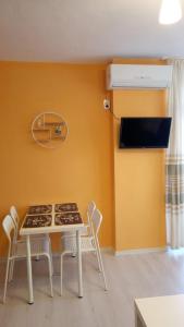 een tafel en stoelen in een kamer met een gele muur bij Ethno guest suite in Primorsko