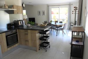 a kitchen with a counter and a dining room at Gite des Cépages in Voiteur