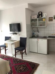 een kleine keuken met een tafel en stoelen en een aanrecht bij Villa Maja in Njivice