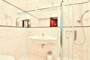 a white bathroom with a sink and a shower at Amber Boutique Hotels - Amber Design in Krakow