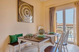 a dining room with a table and chairs and a window at Anaria Gold Suite in Ermoupoli