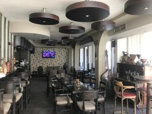 un restaurant avec des tables et des chaises et une télévision au plafond dans l'établissement Villa Piano&Bar, à Ohrid