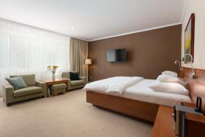オパヴァにあるApartmány Kramerのベッド、椅子、テレビが備わるホテルルームです。