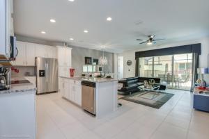 cocina con armarios blancos y sala de estar. en Orlando Newest Resort Community Town Home Townhouse en Orlando