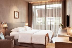 a bedroom with a large bed and a window at The Margi in Athens