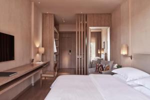 a hotel room with a large bed and a desk at The Margi in Athens