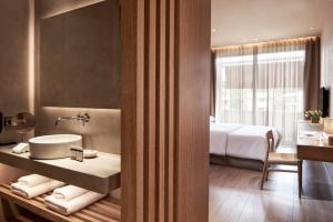 a bathroom with a sink and a bedroom with a bed at The Margi in Athens